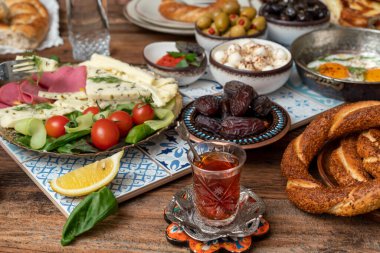Lezzetli zengin geleneksel Türk kahvaltısı arasında domates, salatalık, peynir, tereyağı, yumurta, bal, ekmek, simit, zeytin ve çay fincanları yer alıyor. Ramazan Suhoor diğer adıyla Sahur (oruç tutmadan önce sabah yemeği). 