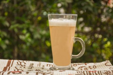 Açık havada cam bardakta kahve.