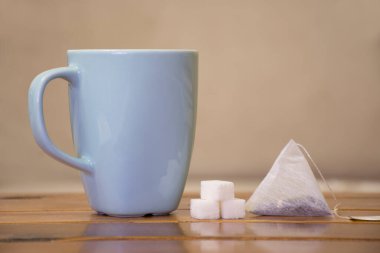Çay poşetli çay, tahta masada şeker küpü.