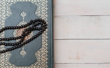 Ahşap zemininde tespih bulunan Kutsal İslam Kitabı Kuran 'ı. Arapça Kur 'an ile. Anlamı: Ramazan Mübarek. Ramazan Kareem. 