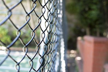 Metal rabitz ızgarasına yakın çekim. Yatay rabitz ağı arka planı. Yeşil çayıra karşı ağ dokusu.