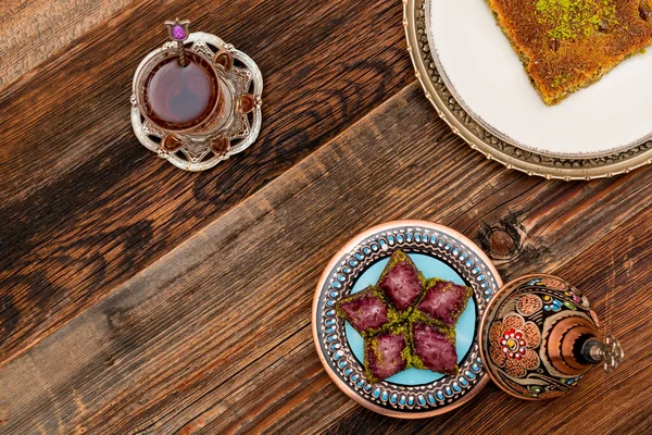 伝統的なトルコのデザートの終わり 木の背景にトルコ茶とピスタチオパウダー ビルマカダイフ と紫のバクラバとカダイフ ラマダーン月に最も人気のある トルコ語 Ramazan Bayrami — ストック写真