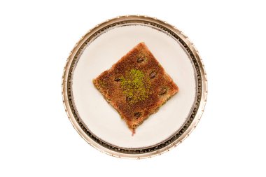 Geleneksel Türk tatlısına yakın plan - Kadayif ve şam fıstığı tozu (Burma kadayif) beyaz arka planda izole edildi. Ramazan ayının en popüler tatlısı (Türkçe: Ramazan bayrami).