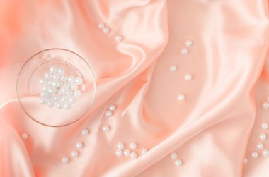 Yumuşak ipek ya da saten kumaş üzerine kristal cam ve beyaz inciler içeren zarif bir kompozisyon. Minimum bileşim. Yumuşak arkaplan.