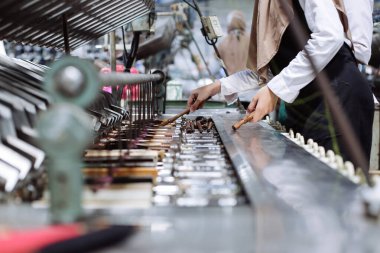 Kadınlar fabrikada iplik diziyor. 