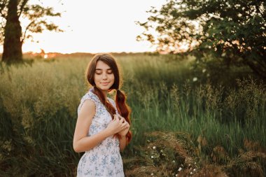 Kız gün batımında papatya otlağında