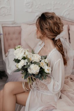 Güzel bir kızın ellerinde bir buket beyaz gül.