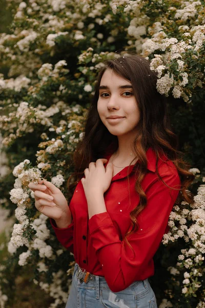 Красива Руда Молода Дівчина Червоній Блузці Навесні Біля Квітучих Кущів — стокове фото