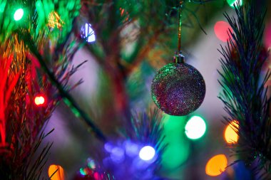 Toplar ve ışıklarla süslenmiş Noel ağacı.