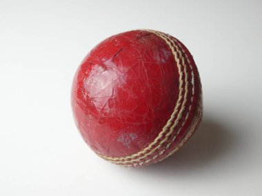 Beyaz arka planda eski kırmızı deri kriket topu