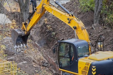 An excavator working on replacing water pipes, an excavator repairing a water main break, maintenance work on a water pipeline section.