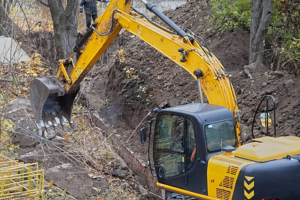 An excavator working on replacing water pipes, an excavator repairing a water main break, maintenance work on a water pipeline section.