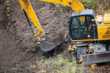 Kovasında toprak olan bir kazıcının yakın çekimi..