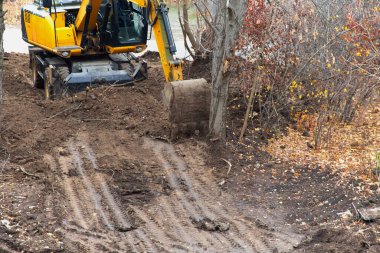 Bir kazıcı inşaatın başlamasından önce son zemini düzleştiriyor.