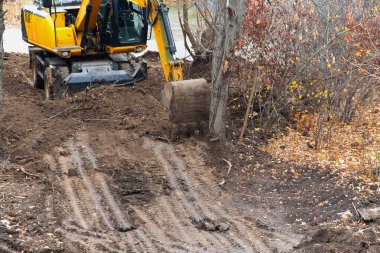 Bir kazıcı inşaatın başlamasından önce son zemini düzleştiriyor.