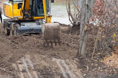 Kovası ile kazıcı inşaat başlamadan önce zemini son düzlemini gerçekleştiriyor..