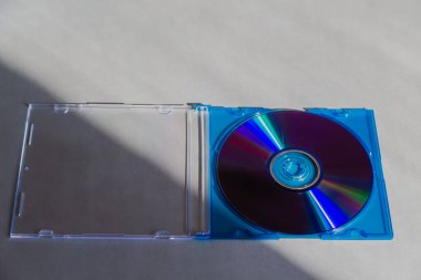 Üzerinde CD olan bir çanta, gri bir masanın üstünde duruyor. Yakın plan. Eski bir dijital medya biçimi. İlgisini ve klasik teknolojisini kaybeden teknolojiler..