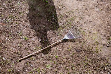 Fan, parlak güneş ışığı ve bir insanın gölgesi altında yerde sürünüyor. Temizlenmiş alanda bırakılan araç, işin tamamlanması ve dinlenmenin başlangıcını simgeliyor.