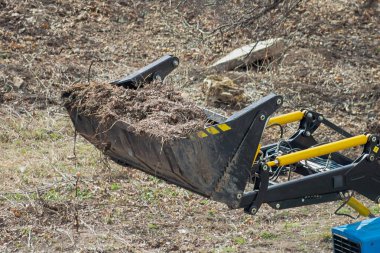 Doldurucunun kovası ahşap enkazla dolu. Belediyenin ön plandaki makineleri boşaltma, çevre düzenlemesi yapıyor..