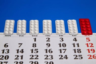 Haftanın her günü mavi bir takvime yerleştirilmiş ilaç paketleri. İlaç tedavisi görüyor.