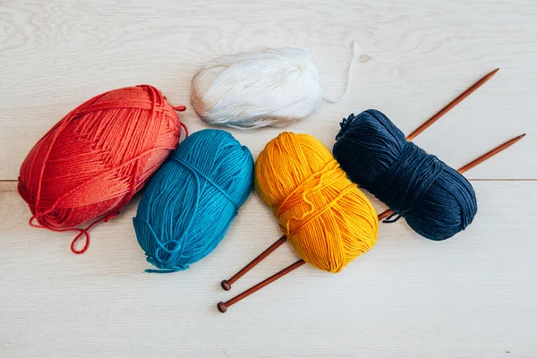 Várias bolas de fio de lã com agulhas — Fotografia de Stock