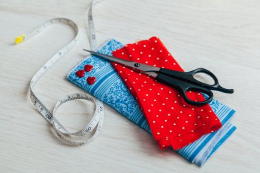 Makas ve metre bandı ile kırmızı kumaş