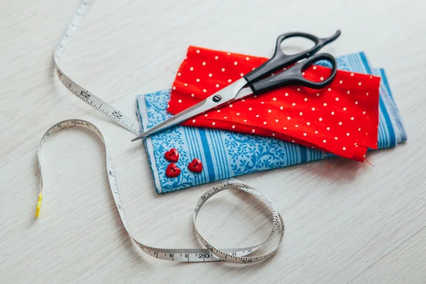 Pano vermelho e azul com tesoura e fita métrica — Fotografia de Stock