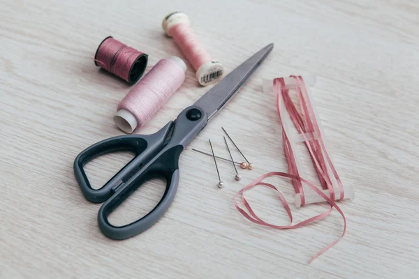 Carretéis de linha de costura rosa com tesoura e arco — Fotografia de Stock