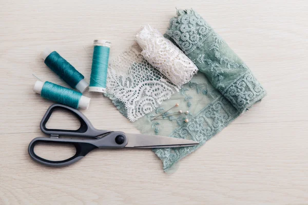 Lace and scissors with blue sewing threads — Stock Photo, Image
