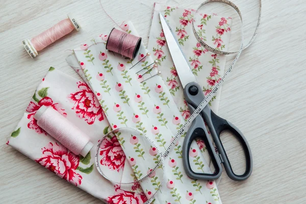 Pink sewing thread spools with various cloth pieces Stock Photo