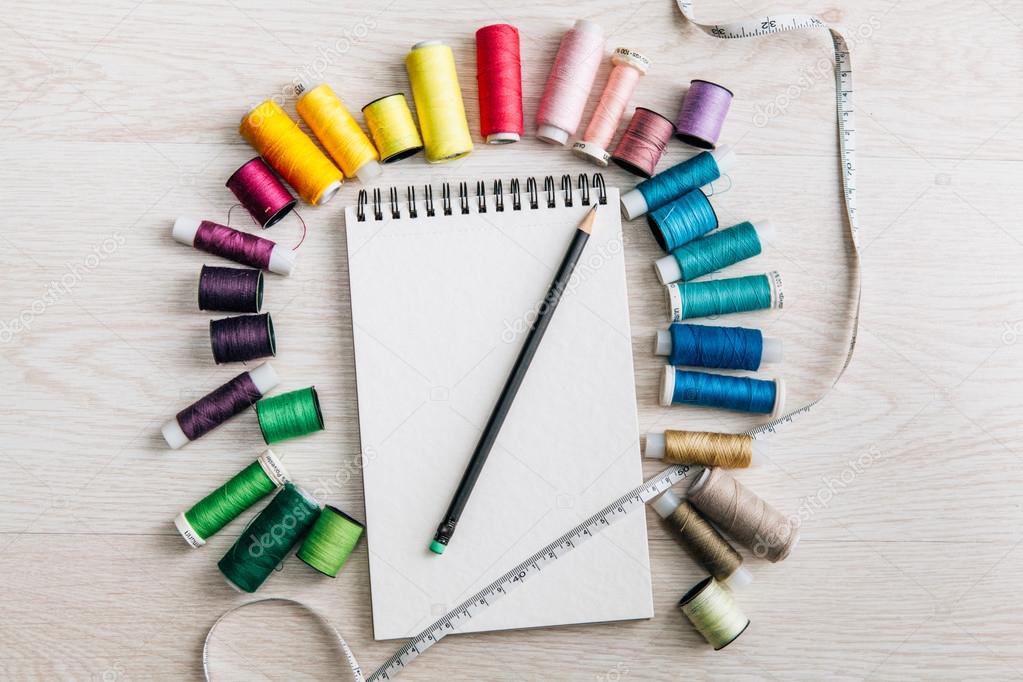 Notebook and colorful sewing thread spools