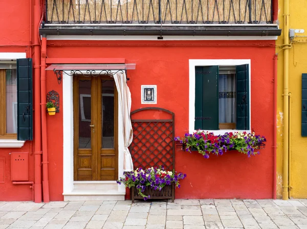 Burano, Italien - 21 maj 2015: röd målad byggnad. En av ma Stockfoto