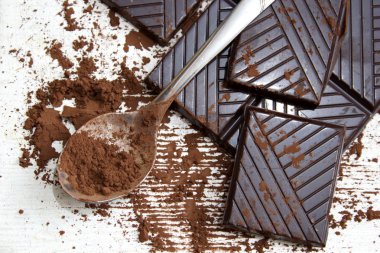 Bir kaşık ve koyu çikolata parçalarını çikolata toz