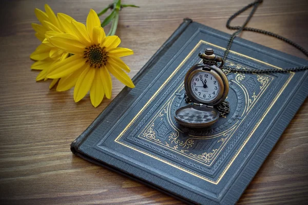 复古口袋手表和黄色花躺在那本旧书 — 图库照片