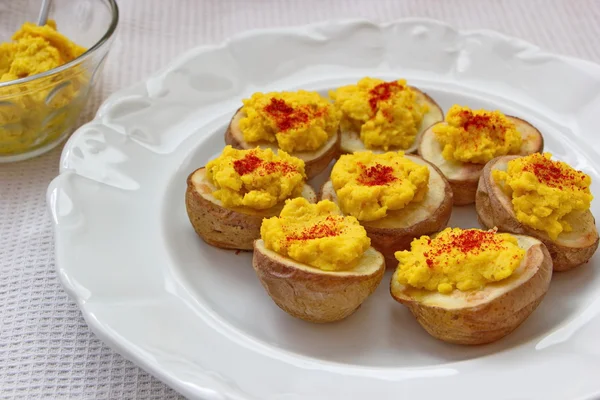 Humus üzerinde fırında patates hizmet biber ile