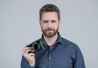 Günlük stilde sakallı adam. Fotoğraf makinesi, gri arka plan, kameraman..