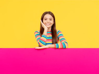 Yakında geliyorum. Pazarlama tasarımın için. Kağıt pankartıyla neşeli bir genç kız. Çocuk duyuru yapıyor. Kağıt çarşafın arkasındaki çocuk. Yararlı bilgi için yer. terfi ve yaratıcılık için yer.