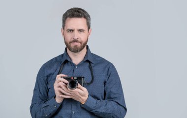 A life well captured. Bearded man hold photo camera. Photographic equipment. Visual art. Professional photography. Photographic studio, copy space.