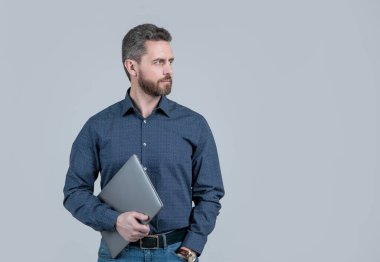 Çevrimiçi dünyayı da yanına al. Mühendis dizüstü bilgisayarı gri arka planda tutuyor. Bilgisayar iletişimi. Kablosuz iletişim. İnternet erişimi. Modern teknoloji, kopyalama alanı.