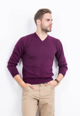 Ciddi görünüşlü çekici bir adam. Ellerini pantolonunun cebinde tutuyor. Sıradan moda tarzında..