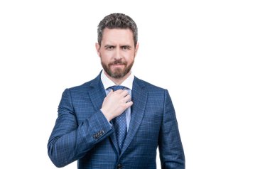 Orta yaşlı menajer, beyaz, iş kıyafetlerinde izole edilmiş, resmi moda tarzında şık mavi bir takım elbise giyerek kravatı düzeltir..