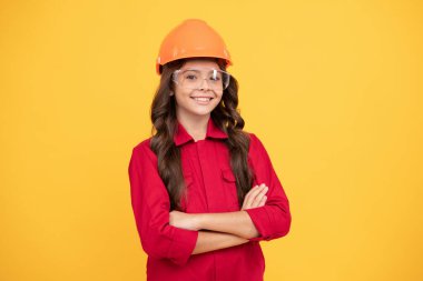 Başarılı olmak. Onarım için güvenlik gözlükleri. İşçi bayramı. Koruyucu gözlüklü gülümseyen çocuk. Çocukluk gelişimi. Neşeli genç kız gözlük ve kask takıyor. çocuk gelecekteki mühendis.