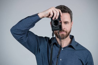 İhtiyacın olduğunda kamera teçhizatı. Sakallı adam kamerayla fotoğraf çek. Fotoğraf ekipmanları. Çekim seansı. Bir fotoğraf hikayesi..