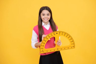 Eğitici bir kavram. Ölçüm. İletgenli mutlu genç kız. Okula dönüyorum. Trigonometri kırtasiyesi. Çocuk matematik okuyor. Kök disiplinler. Çocuk eğitimi. açı derecesi ölçülüyor.