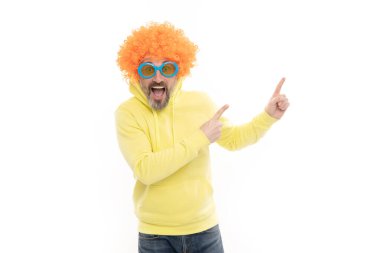 Turuncu peruklu çılgın adam ağzını açık tutuyor ve işaret parmaklarıyla fotokopi alanı için işaret ediyor, reklam yapıyor..