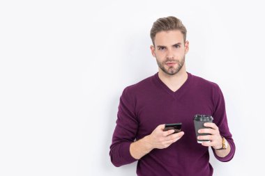 Kafein ve akıllı telefon bağımlılığı. Yakışıklı adam kahve içerken telefon kullanıyor. Teknolojiye bağımlılık. Dijital hayat. Modern yaşam tarzı. Mobil iletişim. Bağlantı alanına adanmış, boşluğu kopyala.