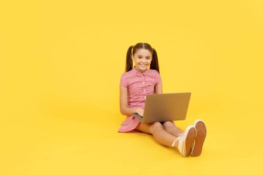 Çocuk satış ve indirim buluyor. İnternet 'te rahat çocuk sörfü. Sosyal medyayı arayın. Siber Pazartesi çevrimiçi. Okula dönüyorum. Modern dijital iletişim. Mutlu genç kız dizüstü bilgisayarda çalışıyor. Boşluğu kopyala.