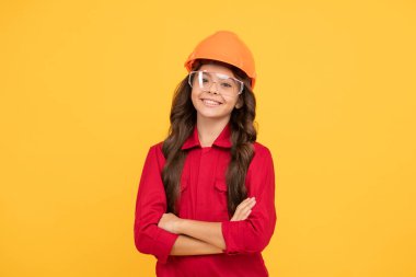 Keyfim yerinde. İşçi bayramı. Çocukluk gelişimi. Koruyucu gözlüklü genç kız. Çocuk gözlük ve kask takıyor. Koruma. Çocuk gelecekteki mühendis. Onarım için güvenlik gözlükleri.