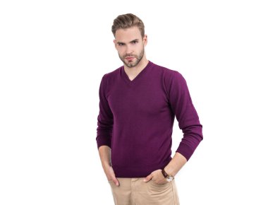 Yakışıklı adam mor kazak giyiyor ve beyaz, çekici bir pantolon giyiyor..