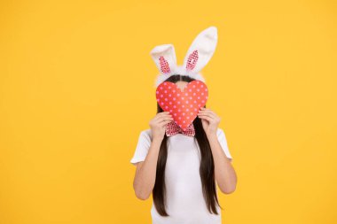 Tavşan kulaklı paskalya çocuğu ve papyonlu aşk kalbini tut, mutlu paskalya eğlencesi.